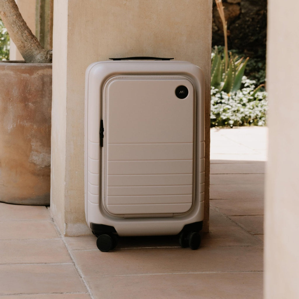 Monos Carry - On Pro Plus Luggage (23"), Hardside Spinner Suitcase with TSA Lock & Front Pocket, Airline Approved, Desert Taupe, Beige