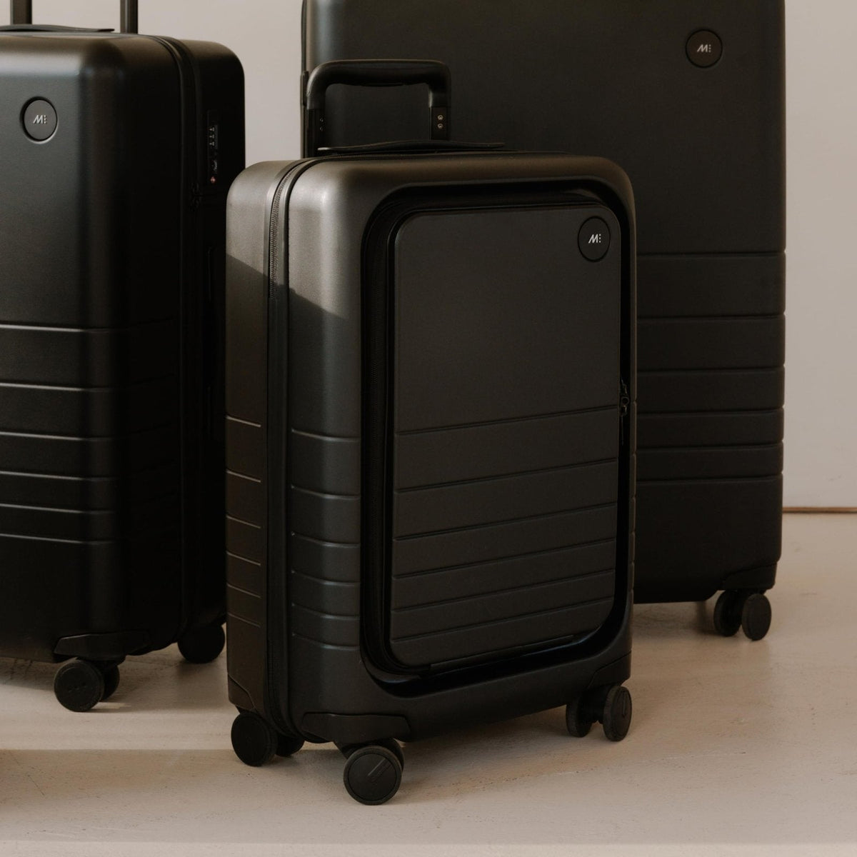 Monos Carry - On Pro Plus Luggage (23"), Hardside Spinner Suitcase with TSA Lock & Front Pocket, Airline Approved, Midnight Black